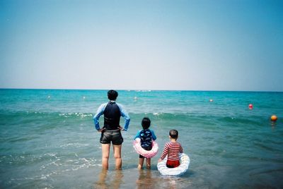 People on beach against clear sky