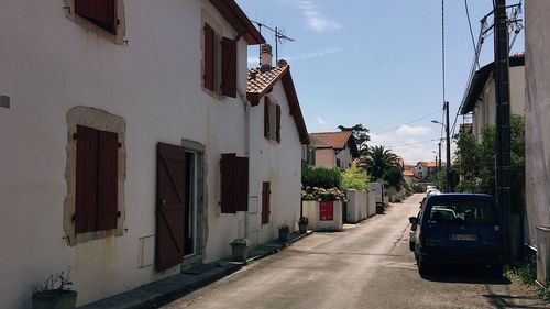 Road amidst buildings against sky