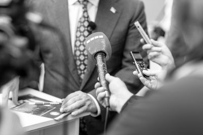 News or press conference or media interview, digital voice recorder and microphone in focus