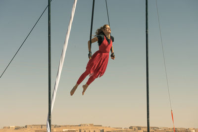 Low angle view of person paragliding against clear sky