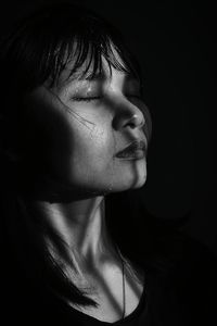 Close-up of girl against black background