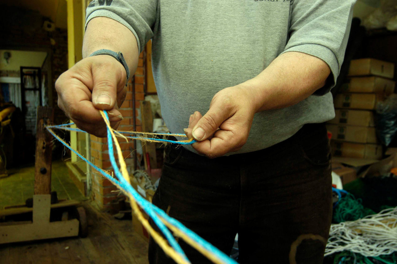 MIDSECTION OF MAN WORKING IN TRADITIONAL CLOTHING