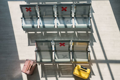 Waiting chairs with social distancing sign and suitcases or luggage at airport terminal 