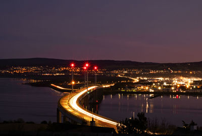 High angle view of illuminated city against sky at night