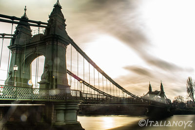 View of suspension bridge against cloudy sky