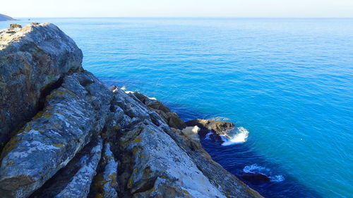 High angle view of rock formation in sea against sky