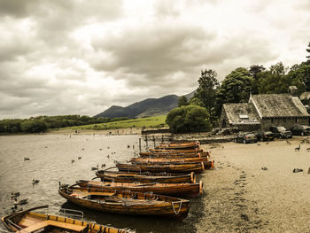 Stack of boats moored at shore against sky