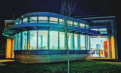 Illuminated building seen through glass window at night