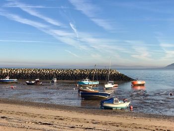 Sailboats moored on sea against sky