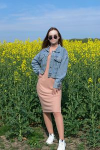 Side view of woman standing on yellow flowering plants