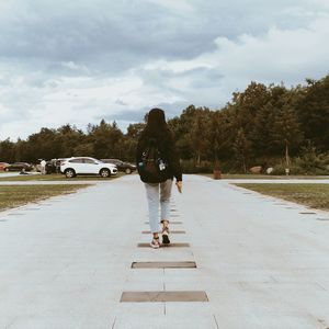 Rear view of woman walking on road