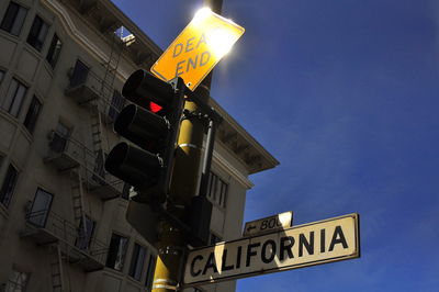 Low angle view of road sign at night