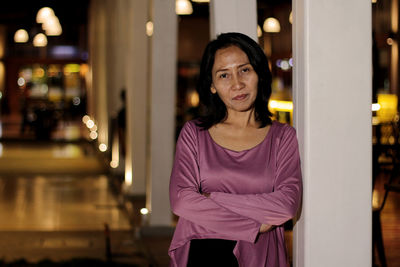 Portrait of smiling woman standing at night