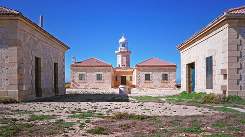 Buildings in city against clear blue sky