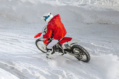 Rear view of man skiing on snow covered field