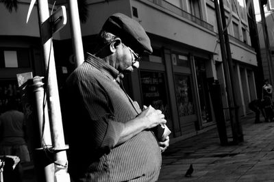 Side view of a man playing in front of buildings