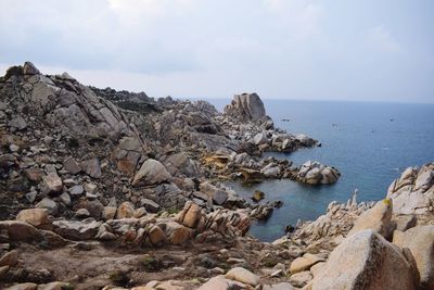 Rocks by sea against sky