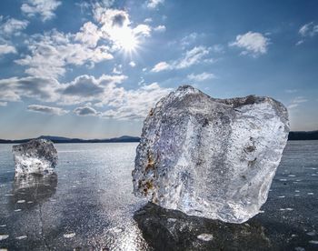 Ice shards on a frozen lake. the rays of the sun creat rainbow shadows in the cracks of the ice.