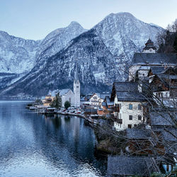 Buildings by mountains against sky during winter