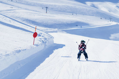 Rear view of boy skiing on snowcapped mountain