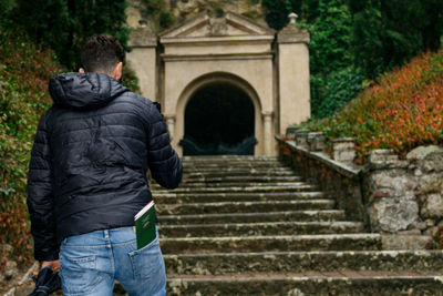 Rear view of man walking on staircase