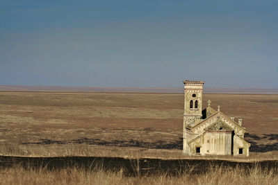 Old building on field against sky