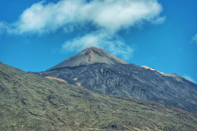 Low angle view of volcanic mountain against blue sky tenerife