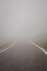 Empty road against sky during foggy weather