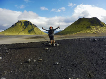 Hiker standing on field against mountains