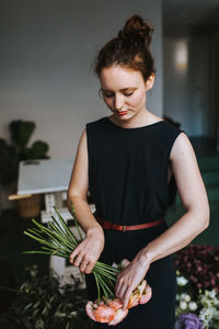 Young woman looking away while standing on cutting board