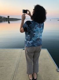 Rear view of woman photographing sea