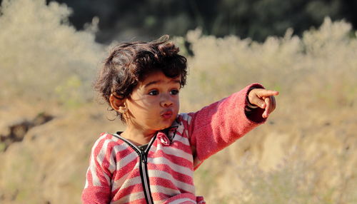 A little boy of indian origin is seen looking away from his finger and hand. facial reaction, face