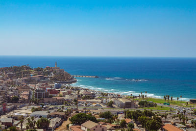 High angle view of buildings by sea against clear sky