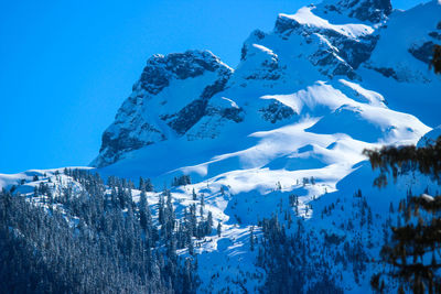 Scenic view of snowcapped mountains against clear blue sky