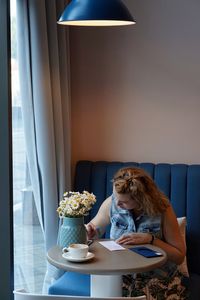 Woman sitting on table at home