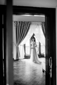 Woman standing on field seen through curtain