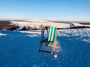 Relaxing chair and a cup of coffee in winter on a sunny day