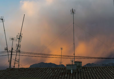 Electricity pylon against sky during sunset