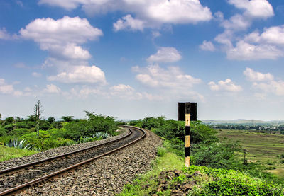 Railroad tracks on field against sky