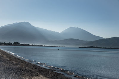 Scenic view of sea and mountains against sky