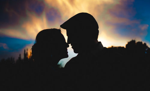 Silhouette couple against sky during sunset