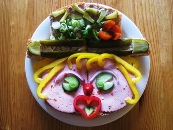 High angle view of anthropomorphic face made from bread and vegetables