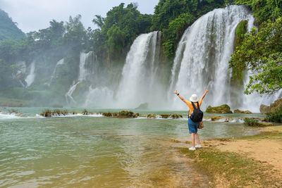 Full length of man surfing in waterfall