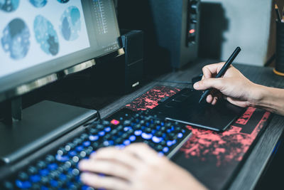 Cropped hand of person drawing in computer