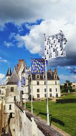 Flags in front of historical building against sky