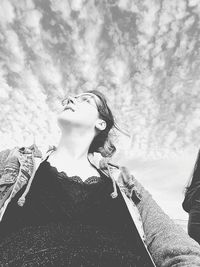 Low angle view of woman looking at camera against sky