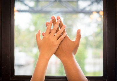 Close-up of woman hand on glass window