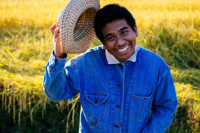 Portrait of smiling young man standing on field
