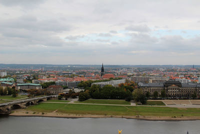 Buildings in city against cloudy sky