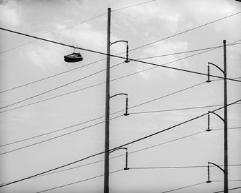 Low angle view of power lines against sky